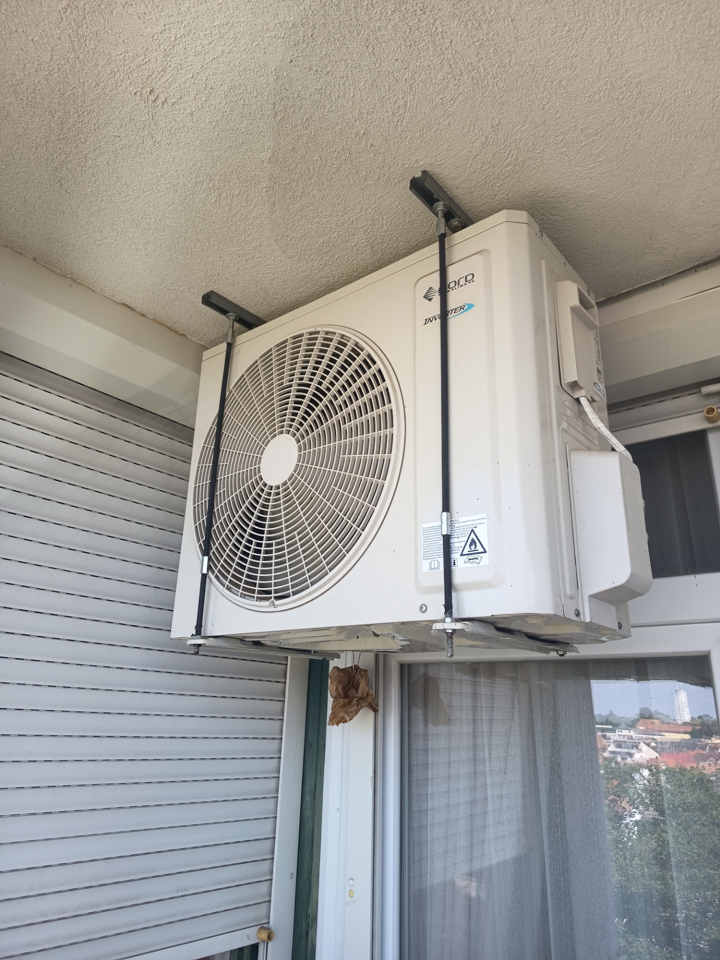 Klímaberendezés kültéri egysége beltéri ablak fölött, ventilátorrács és csatlakozócsövek láthatók. Lovász Etelka Mohács 